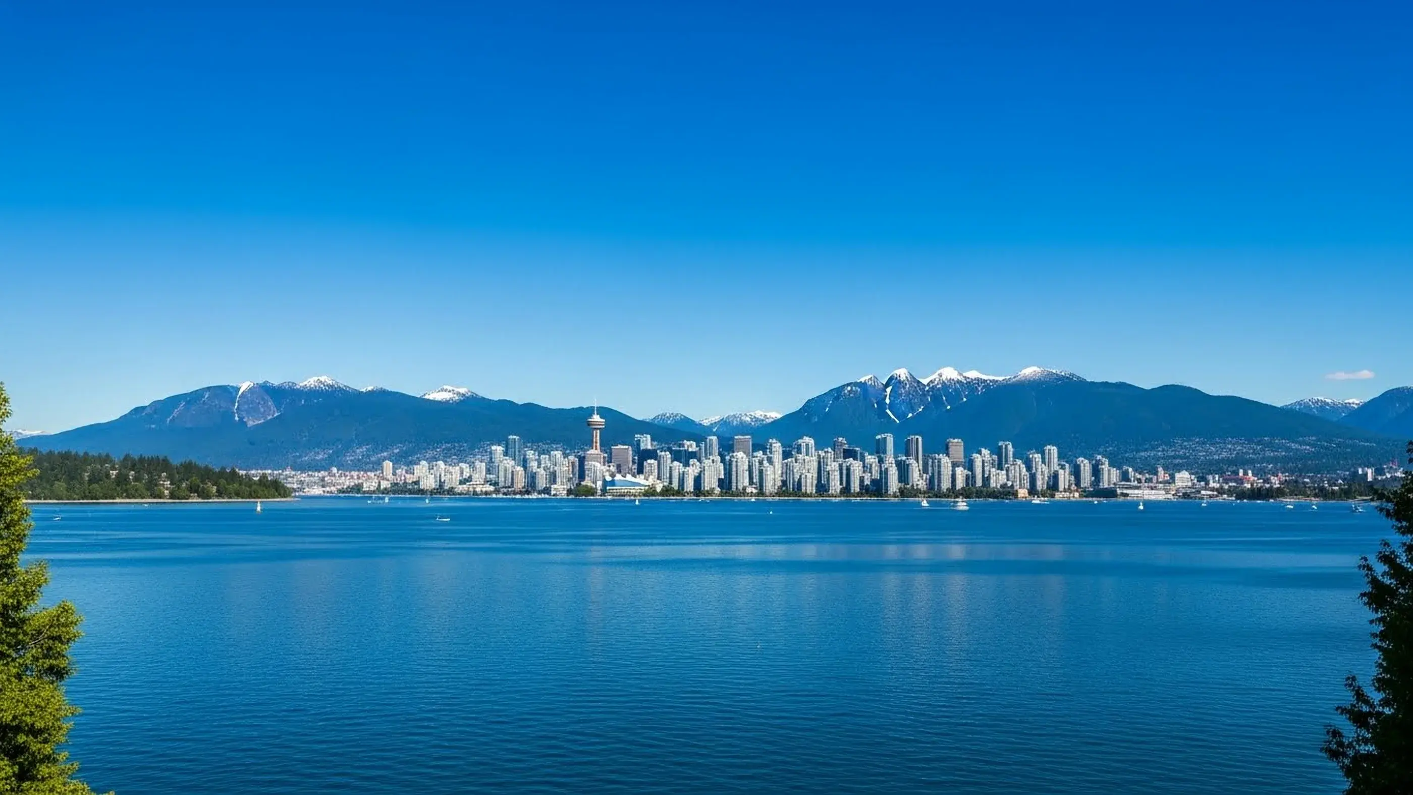 Vancouver, Canada Panoramic view of the Vancouver skyline and Burrard Inlet with snow-capped North Shore Mountains in the background.